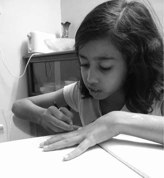 arunima as a child, drawing at a table